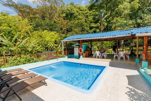 una piscina con sillas y una casa en Casa Mar, en Quepos