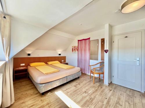 ゴットマーディンゲンにあるHotel-Heilsbergのベッドとテーブルと椅子のある寝室