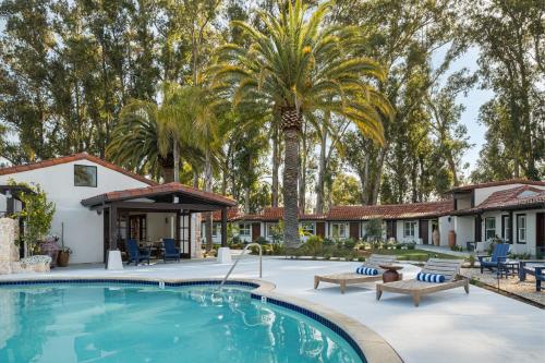 a swimming pool in front of a house with a palm tree at Casia Inn in Sonoma