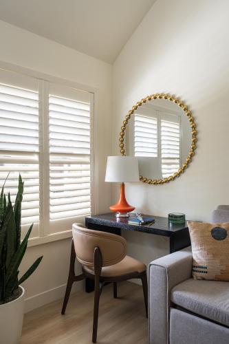 a living room with a table and a chair and a mirror at Casia Inn in Sonoma