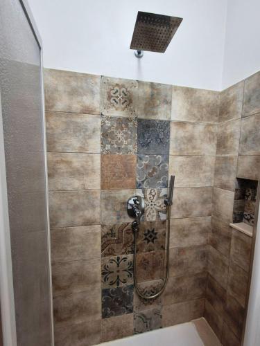 a shower in a bathroom with a tile wall at Timbuktu Hostel in San Vito lo Capo