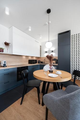 a kitchen with a wooden table and two chairs at Apartamenty Rocha in Pabianice