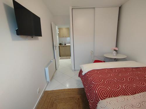 une chambre avec un lit et une télévision à écran plat dans l'établissement zen, à Dammarie-les-Lys