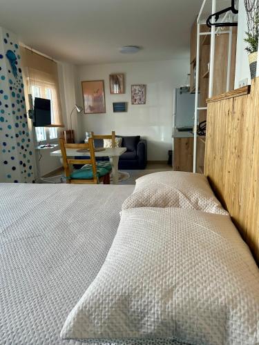Un dormitorio con una cama y una sala de estar. en La medusa flamenca, en Santa Pola