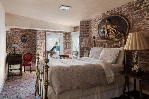 a bedroom with a large bed and a brick wall at Chateau Tivoli Bed and Breakfast in San Francisco