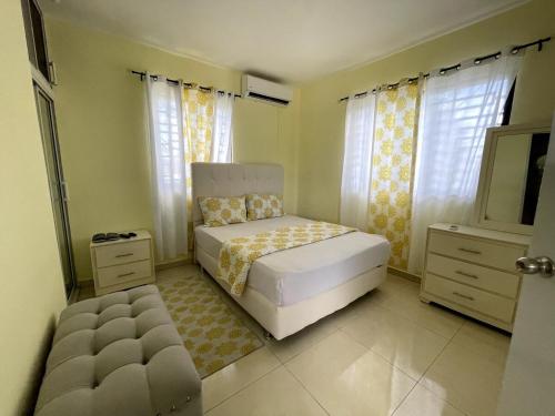 a bedroom with a bed and a dresser and windows at Apartamento Costero 3 en Las Galeras de Samaná in Las Galeras