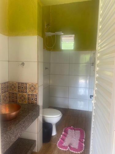 a bathroom with a toilet and a sink and a window at CHALÉS MARICOTA in Vargem Bonita