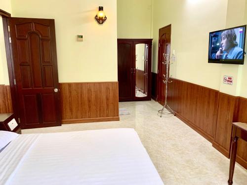 a room with a bed and a tv on the wall at Hung Vuong Hotel in Ben Tre