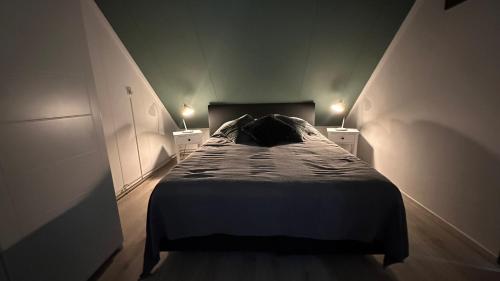 a bed in a room with two lights on at Beach-house27 in Egmond aan Zee