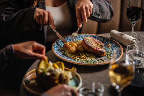 a person eating food on a table with a plate of food at Hyatt Place Gothenburg Central in Gothenburg