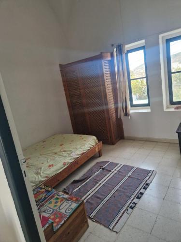 a bedroom with a bed and a rug on the floor at Villa de charme dans quartier calme in Mornag