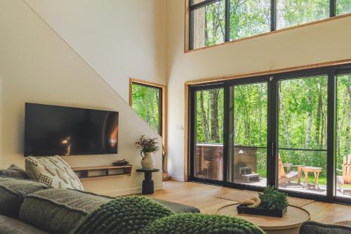 a living room with a couch and a flat screen tv at Snohaus 9 - Scandinavian Mountain Chalet in Mont-Tremblant