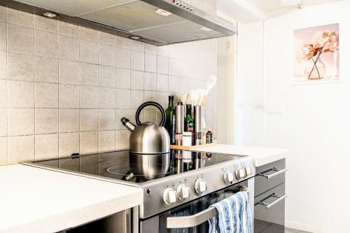 a kitchen with a stove with a tea kettle on it at Private 3 BR Villa! Jacuzzi Fireplace Near Lund and Malmö in Kävlinge
