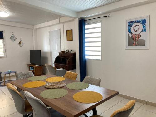 a dining room with a wooden table and chairs at Maison Les Abymes - Plage à 50m in Le Prêcheur
