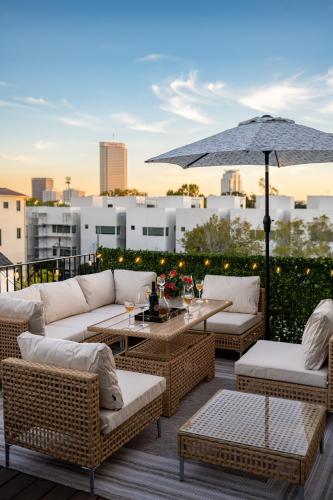a patio with wicker furniture and an umbrella at Thompson Luxuries 4BR Modern Townhome in Rice Military in Houston
