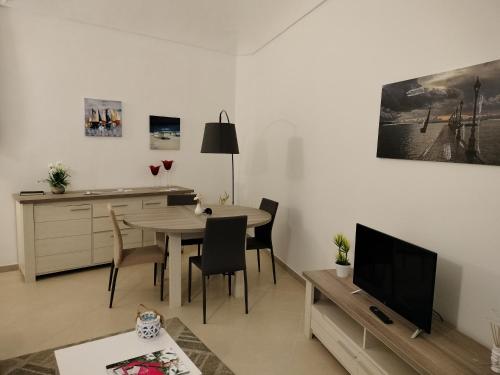 a living room with a table and a dining room at Sunset Ortigia-locazione turistica in Syracuse