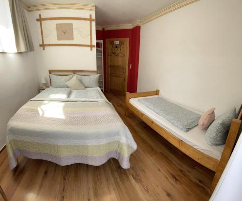two beds in a room with wooden floors at House LA Neuschwanstein Blick - Budget City Hotel in Füssen