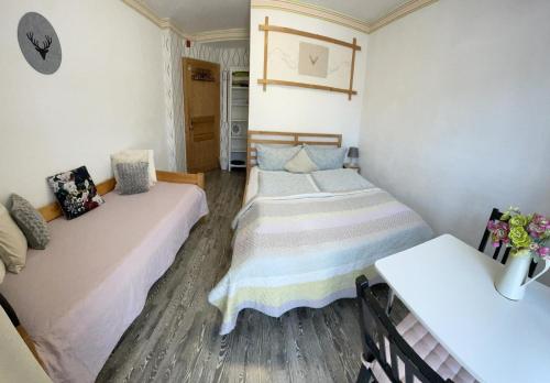 two beds in a small room with flowers on the wall at House LA Neuschwanstein Blick - Budget City Hotel in Füssen
