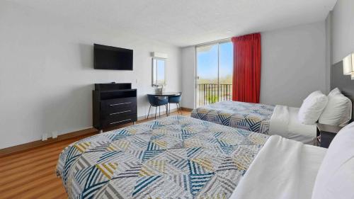 a hotel room with two beds and a television at Motel 6 Atlanta GA Atlanta Airport Virginia Ave in Atlanta