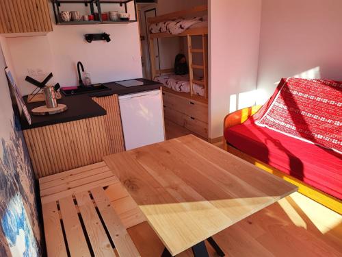 - une cuisine avec une table et un lit dans une chambre dans l'établissement Charmant Studio -La Foux d'Allos, à Allos
