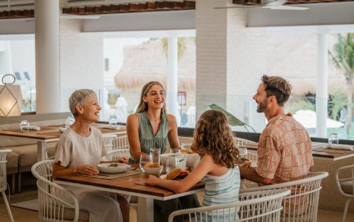 a group of people sitting at a table in a restaurant at Melia Casa Maya Cancun All Inclusive in Cancún