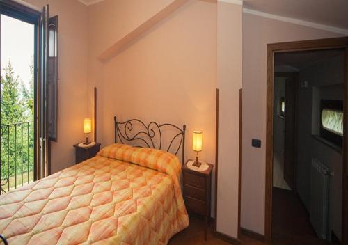 a bedroom with a bed and a balcony with a tv at I Tre Tigli - Casa di campagna in Rutino