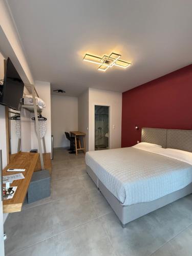 a bedroom with a bed and a red wall at RoomElioti Apartments in Ofrínion