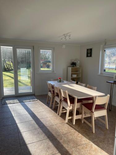 a dining room with a white table and chairs at Country Lodge Lärkboet in Laholm