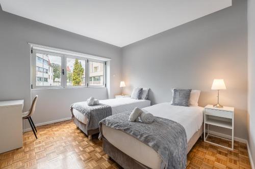 a bedroom with two beds and a window at GuestReady - Charming City Escape in Braga