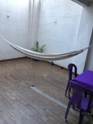 a hammock in a room with a table and a purple bench at La Merced Nobsa Apartahotel in Nobsa