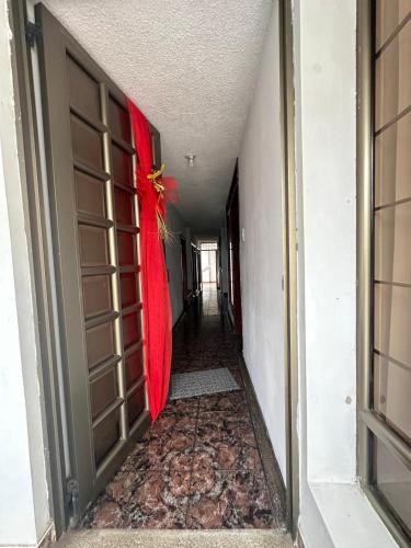 an empty hallway with a red cloth on the door at La Merced Nobsa Apartahotel in Nobsa
