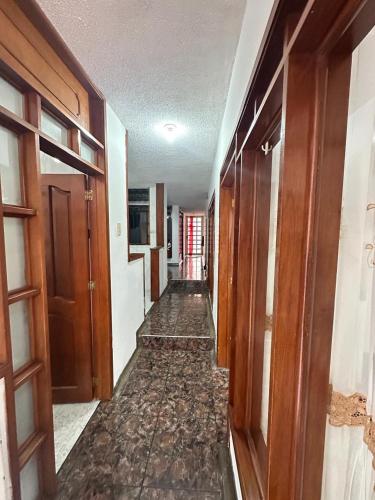 an empty hallway with wooden doors and a hallwayngth at La Merced Nobsa Apartahotel in Nobsa