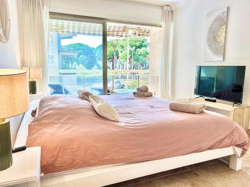 une chambre avec un grand lit avec une grande fenêtre dans l'établissement Luxurious 2-bedroom Pointe Croisette, Sea view, private parking, à Cannes