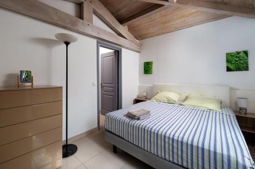 une chambre avec un lit dans une pièce avec des plafonds en bois dans l'établissement Maison niçoise, jardin, piscine, parking double, à Nice