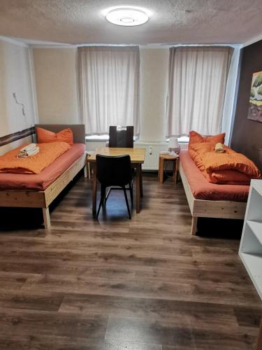 a room with two beds and a table in it at SaxonyBNB in Waldheim