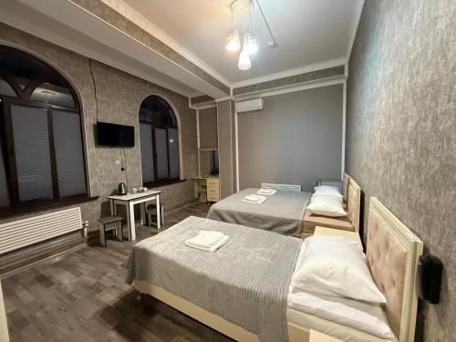 a hotel room with two beds and a television at Delfin Hotel & Restaurants & Spa in Ganja