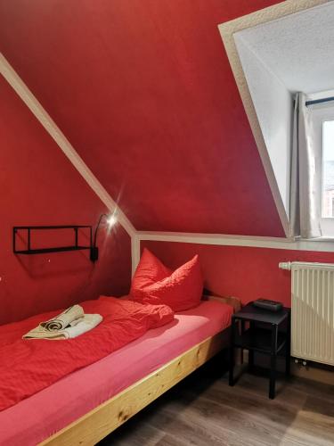 a red room with a bed with red walls at SaxonyBNB in Waldheim