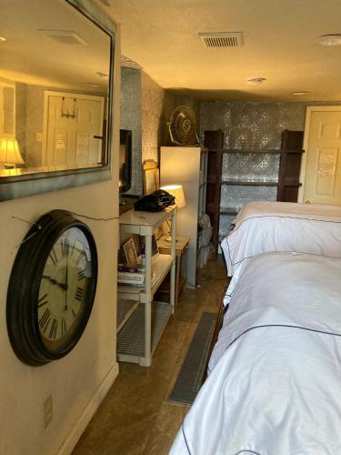 a room with two beds and a clock on the wall at Highland Park Pittsburgh in Pittsburgh
