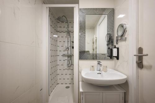 a white bathroom with a sink and a shower at Hotel des Congrès et Festivals in Cannes