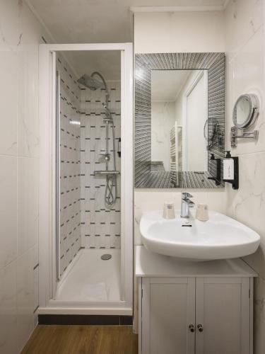 une salle de bain blanche avec un lavabo et une douche dans l'établissement Hotel des Congrès et Festivals, à Cannes