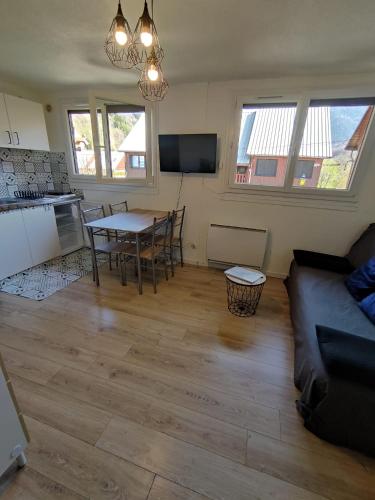 un salon avec une table et un canapé dans l'établissement Le ThiCha Alpe d'Huez Gd Domaine Allemond ThiLuCha, à Allemont