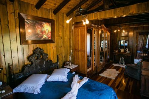 a bedroom with a blue bed and wooden walls at Casa da Família no Sítio Mannes in Antônio Carlos