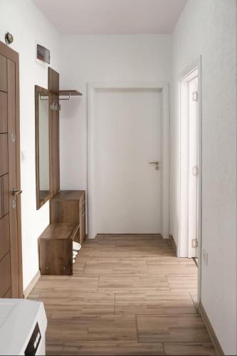 a white room with a hallway with a mirror and a door at Apartament za gosti Zlatograd in Zlatograd