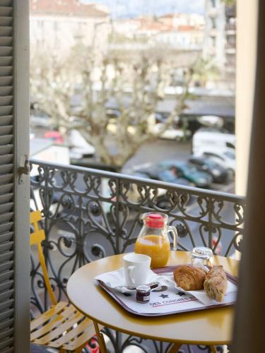 - une table avec une tasse de café et des croissants sur un balcon dans l'établissement Hotel des Congrès et Festivals, à Cannes