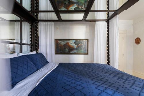 a bedroom with a bed with a blue comforter at Chateau Tivoli Bed and Breakfast in San Francisco