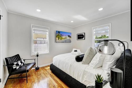 Un dormitorio blanco con una cama y una silla. en Casita Lake Worth - BEACH LIFE!, en Lake Worth
