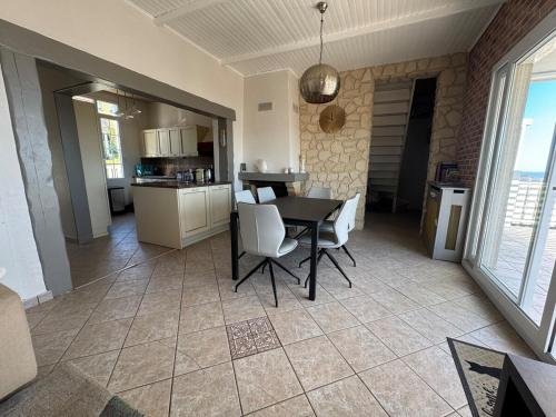 une cuisine et une salle à manger avec une table et des chaises dans l'établissement Villa Hortense Maison vue mer, à Ault