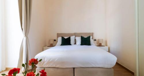 sypialnia z białym łóżkiem z zielonymi poduszkami w obiekcie Musto Suites & Rooms w mieście Neapol