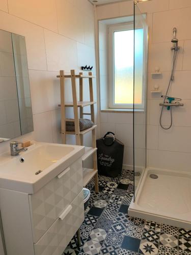 une salle de bain avec un lavabo et une douche dans l'établissement Maison à Morgat proche plage et commerces, à Crozon