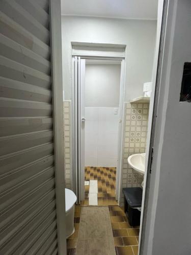 a small bathroom with a toilet and a sink at Apartamento 101 - Suíte ampla para grupos e empresas in Patos de Minas